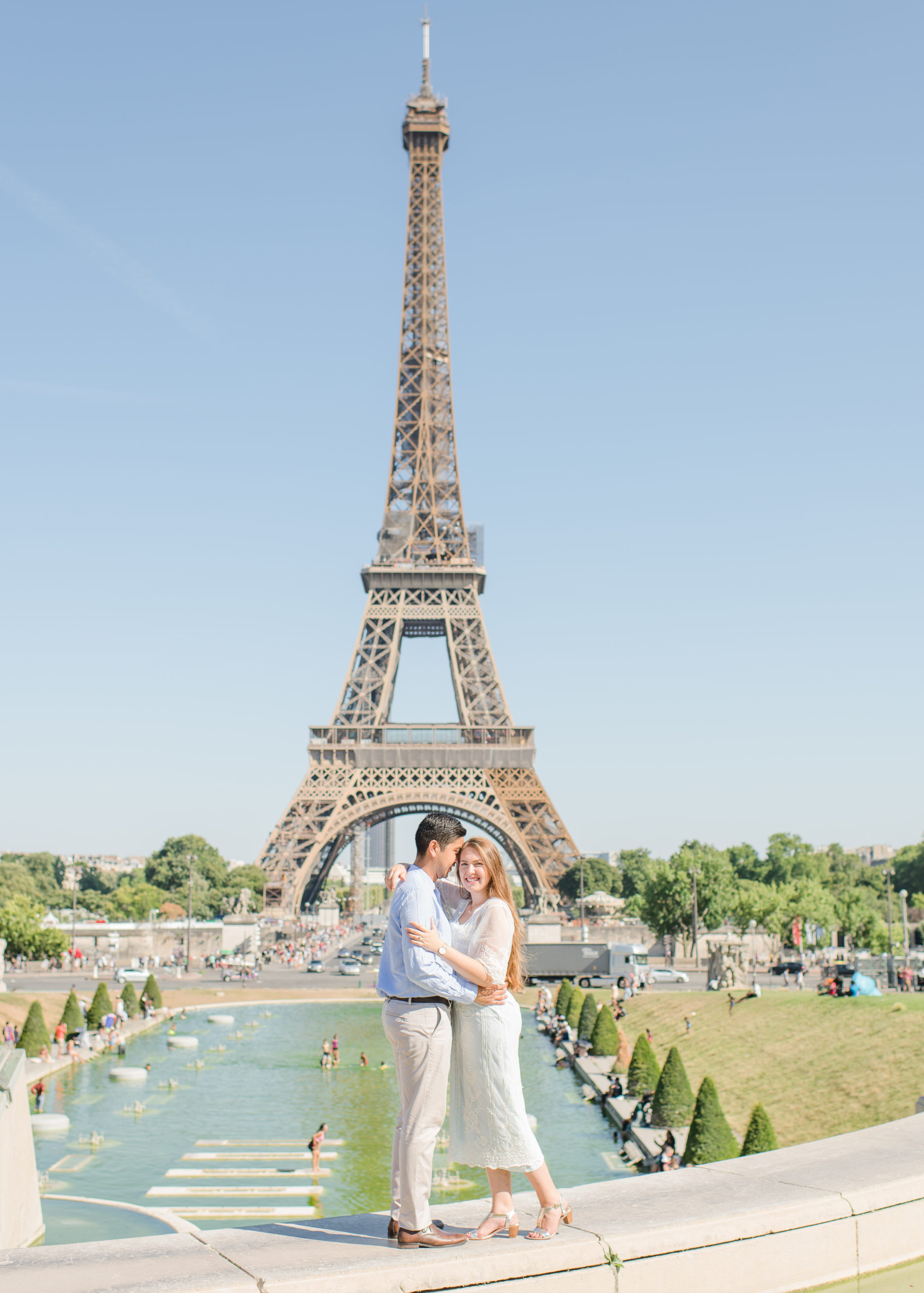 couple posing in front of the eiffel tower in france