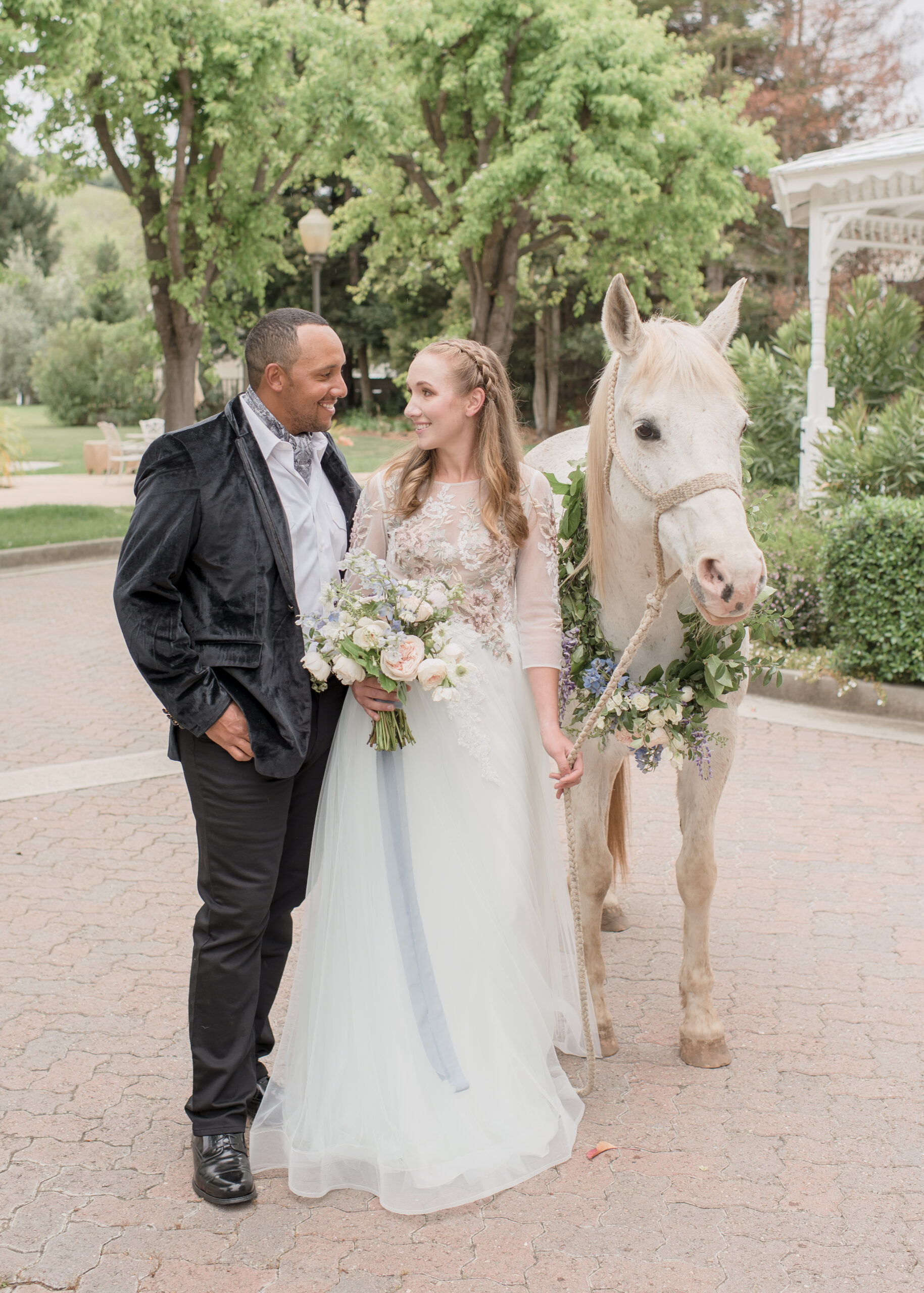 bride and groom pose with white horse