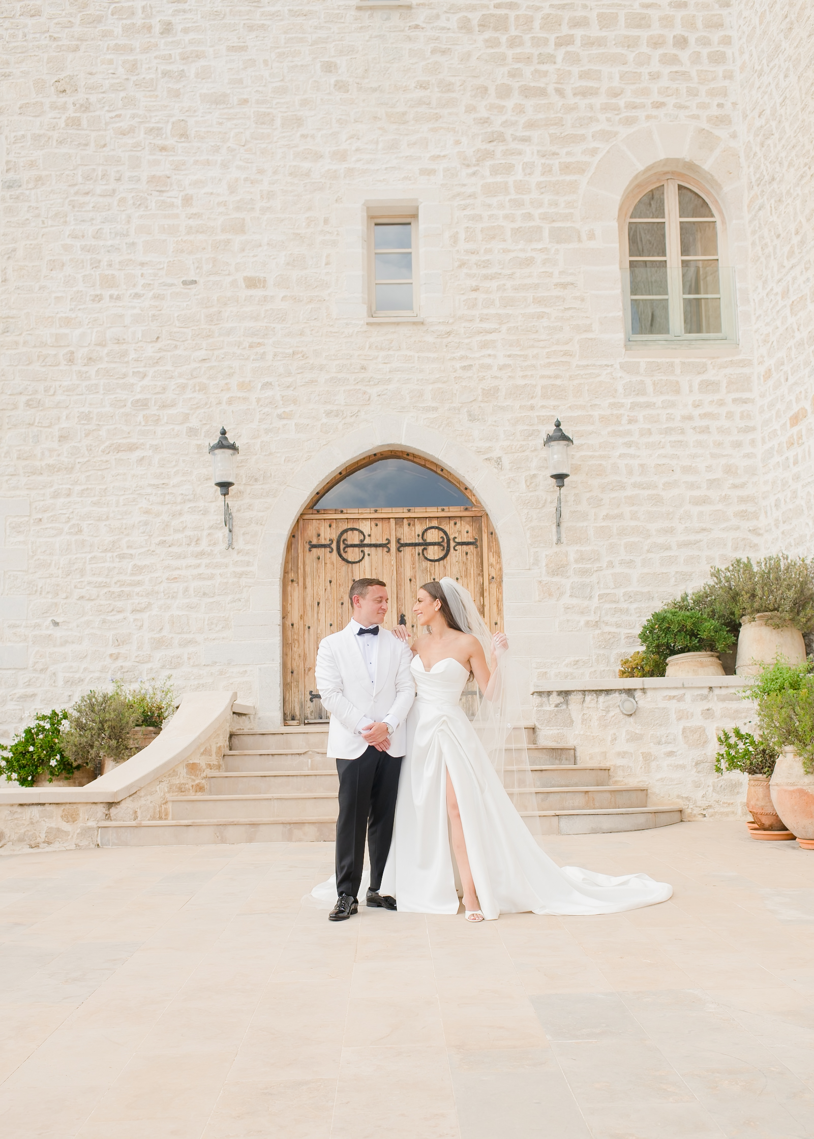 bride and groom in front of wooden door at chateau in south of france