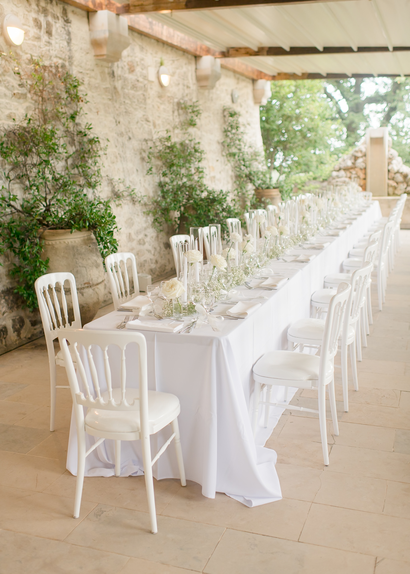 wedding reception with white table cloth, white chairs, and white roses 