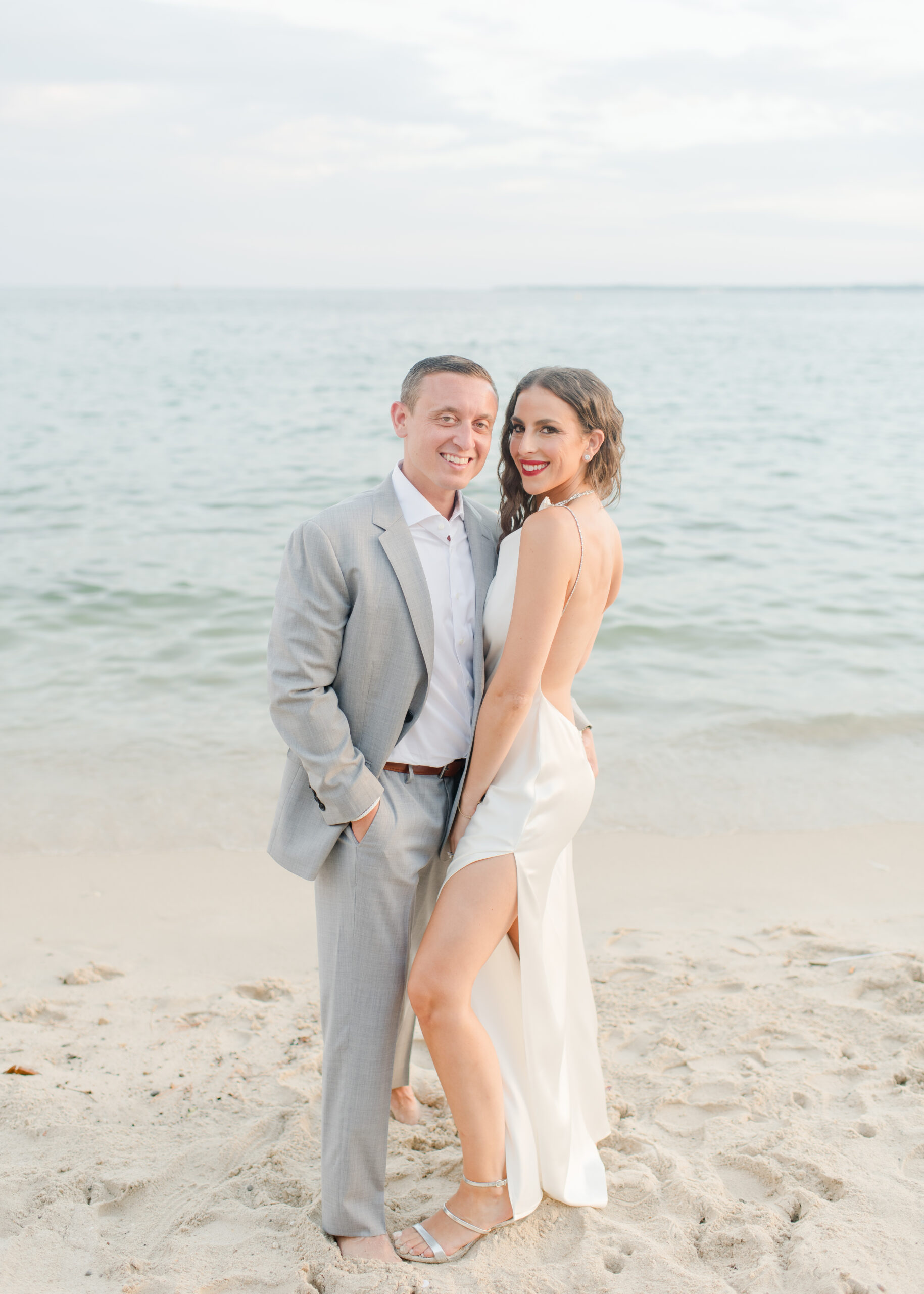 wedding couple facing the camera on the beach