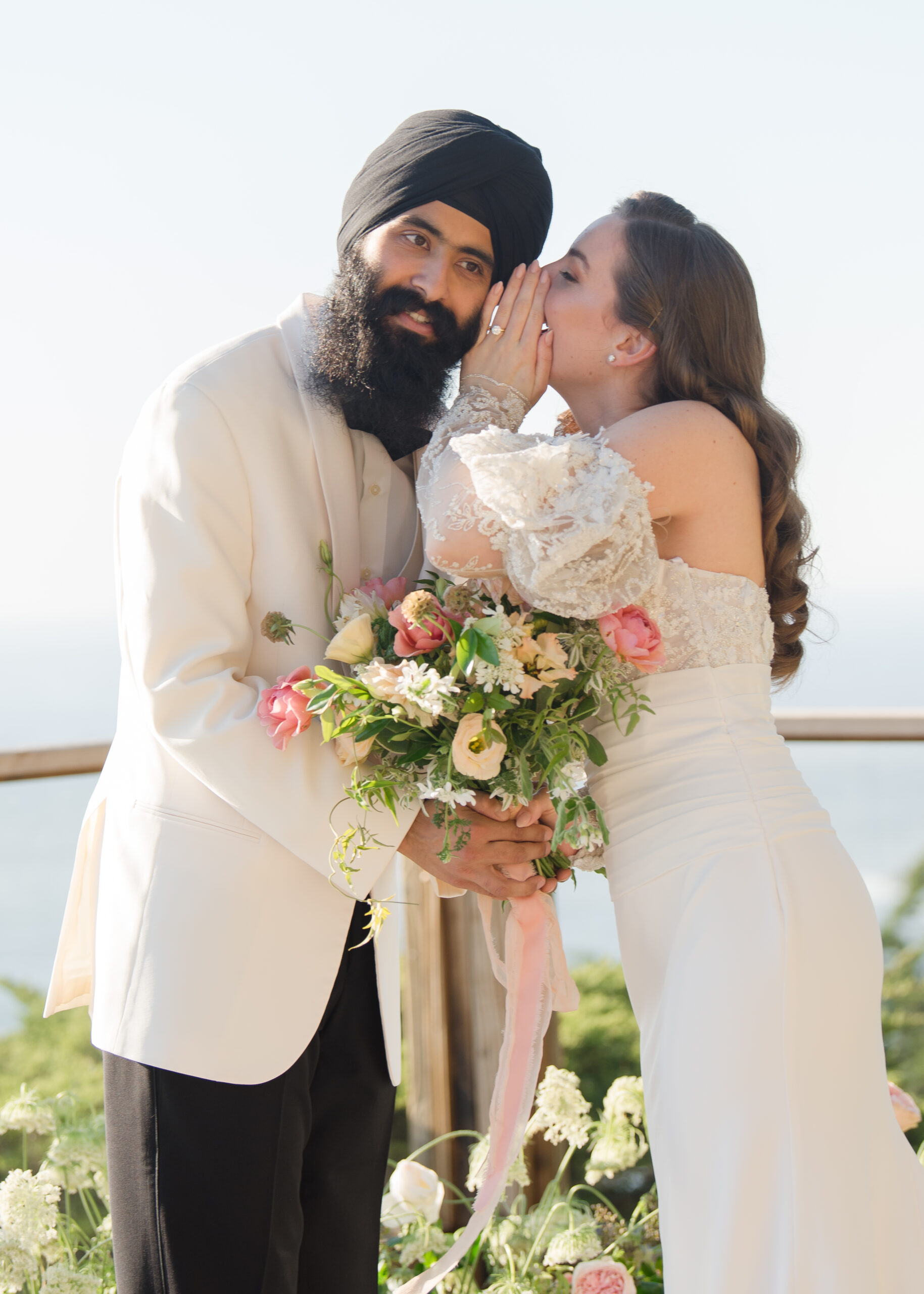 bride whispering  in grooms ear at ceremony arch