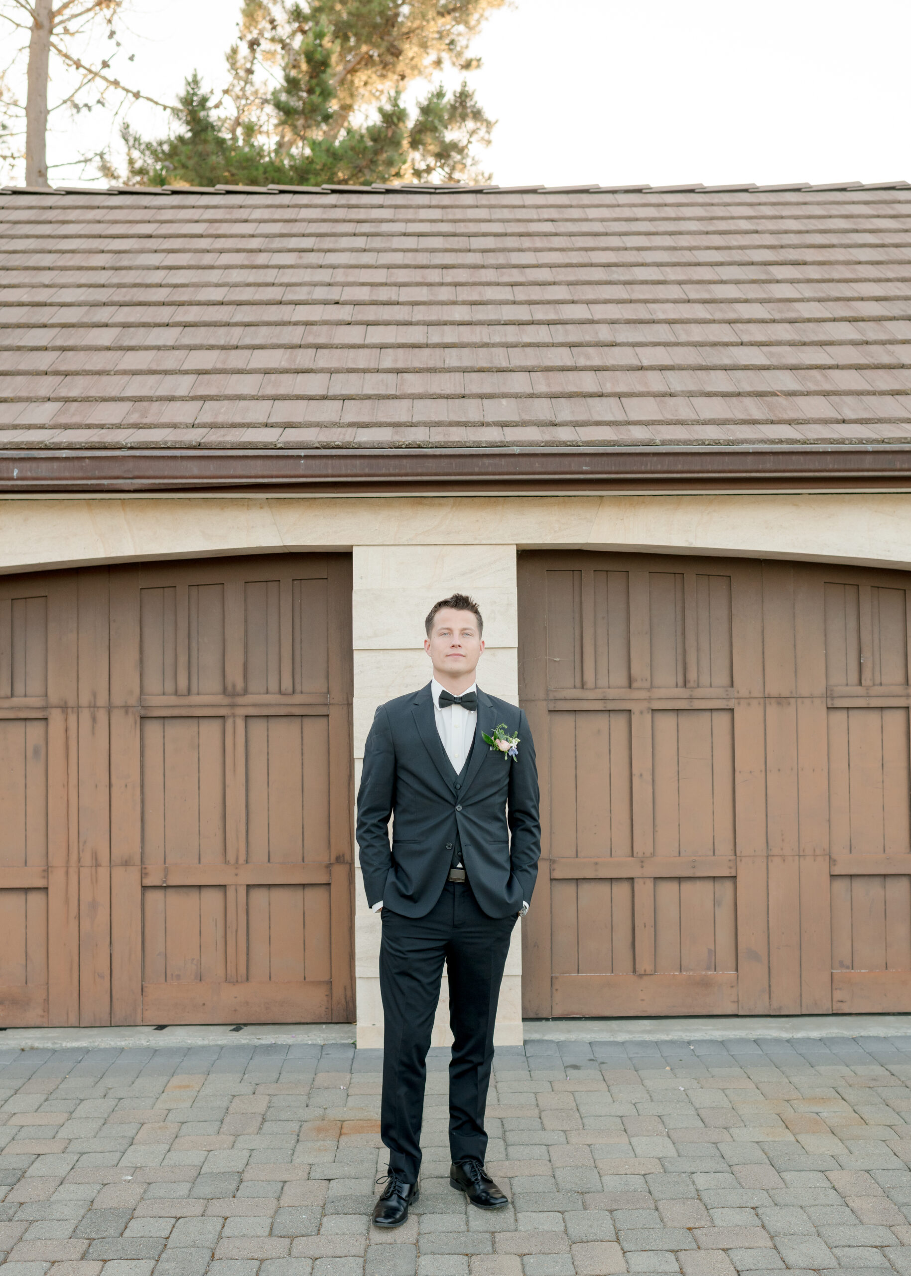 photo of groomsman in front of garage at vineyard