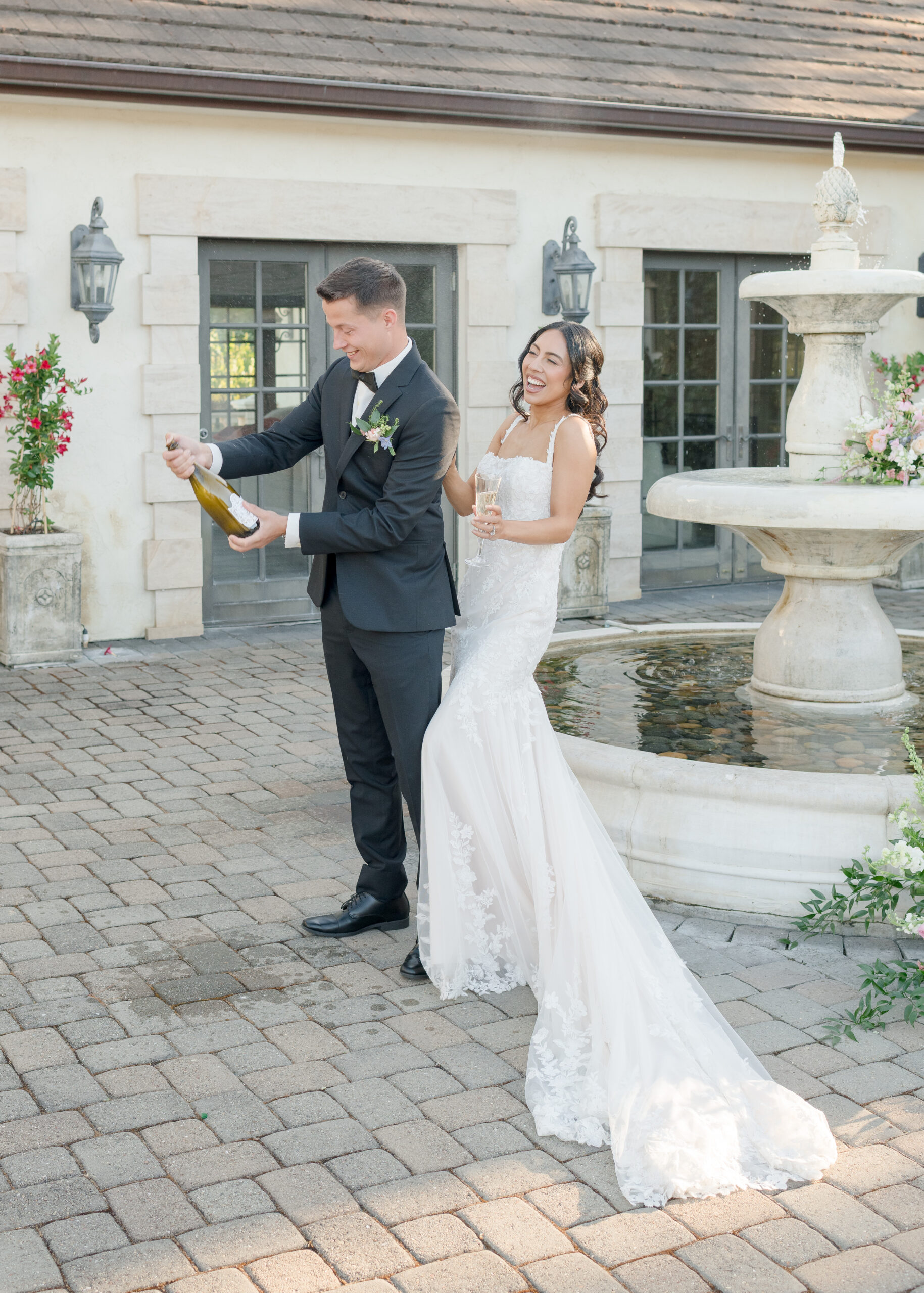 wedding couple popping bottle of wine.