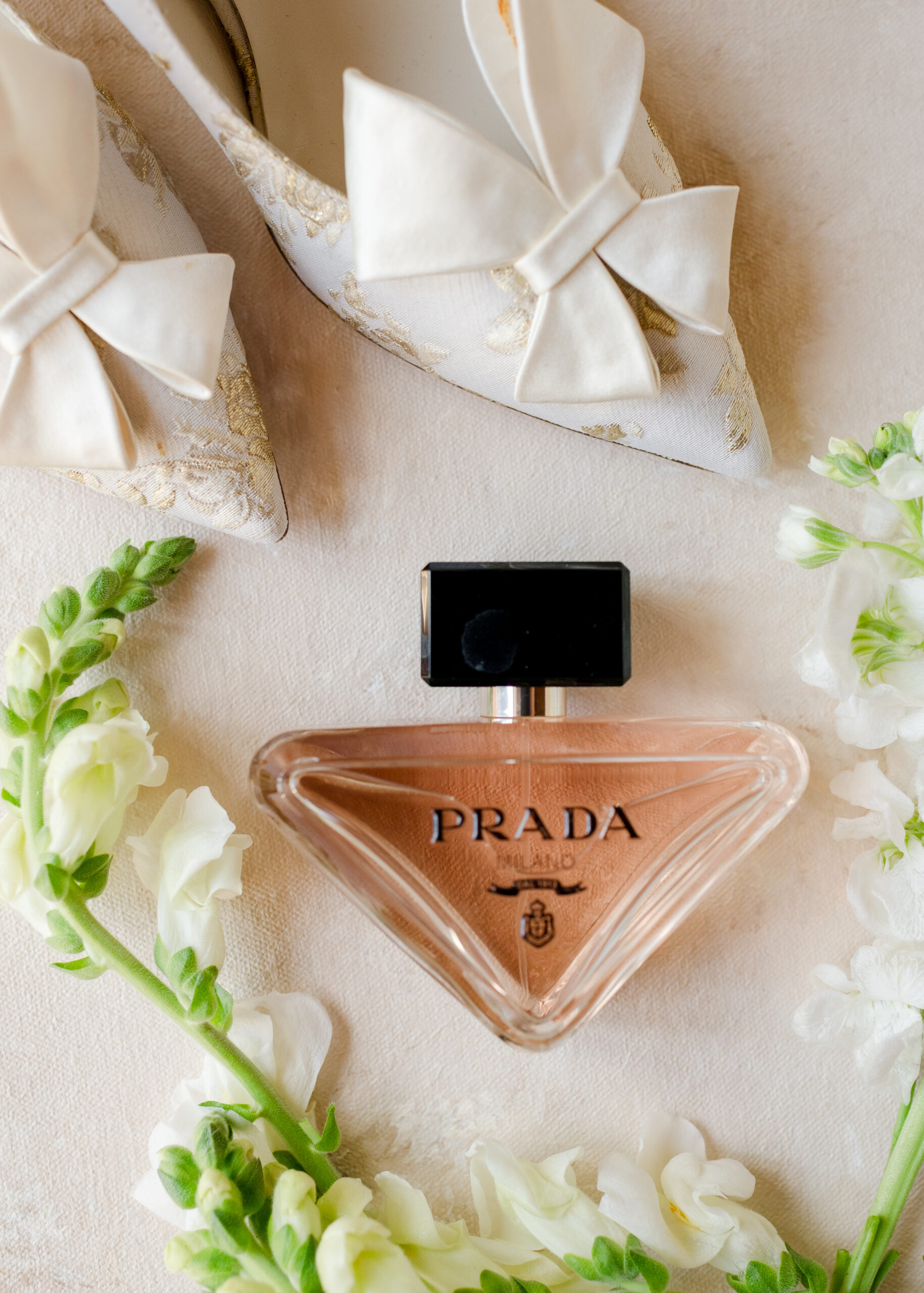 prada perfume with gold and white wedding shoes