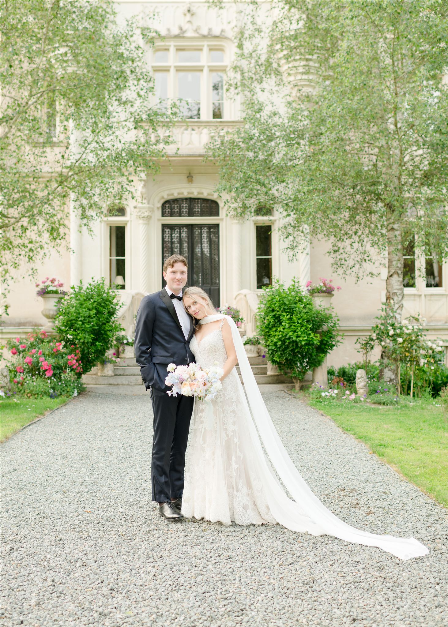 bride and groom in front of chateau in france